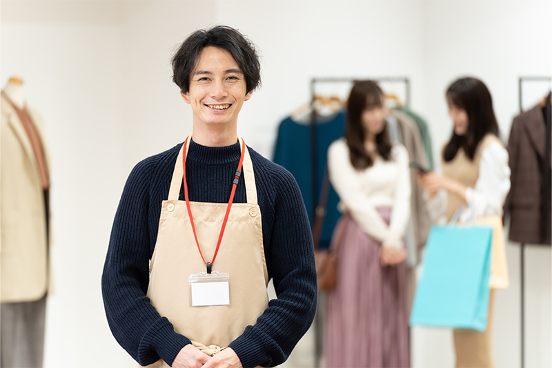 アパレルショップにいるエプロン姿の男性