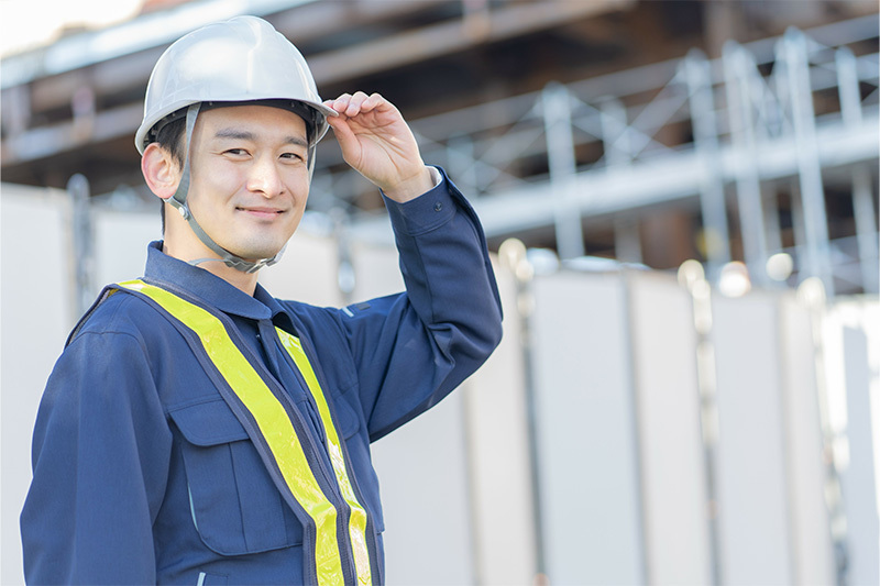 建設現場の前にいる作業着の男性