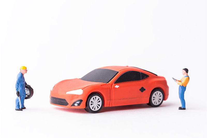 赤い車と作業着姿の男性と男性のミニチュア